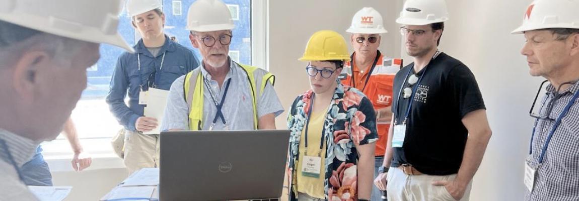 people looking at someone demonstrating some techniques on their laptop