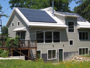 Trail Magic, S and W sides showing PV panels, deck and sun patio; a positive energy home in Oberlin, OH