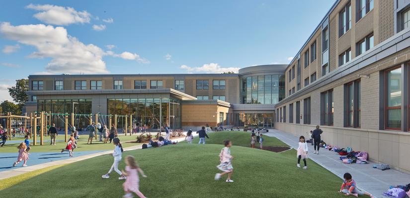 Exterior photo of school campus with children playing